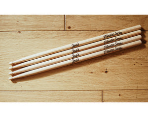 two pairs of Joe's Master Series 5A American Hickory Drumsticks on wooden background